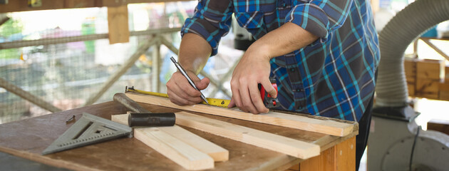 Hands of person doing diy project at home. Man measuring wood to doing cabinet craftworks as a hobby.
