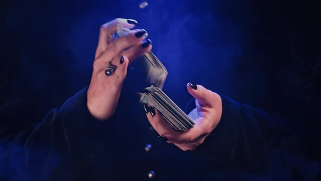 Woman witch shuffles tarot deck, preparation for consultation on predicting future destiny. Fortune teller, medium, divination cards. 