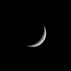 Fototapeta na wymiar Crescent moon shining bright in the dark night sky 