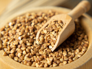 buckwheat in a wooden bowl and scoop close-up