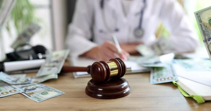 A hammer for auction and dollars on a doctor table
