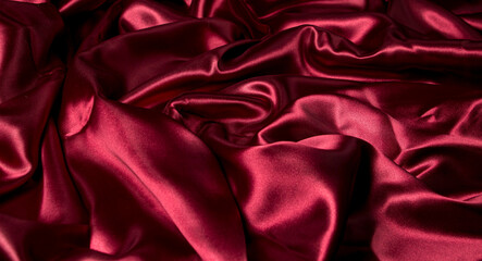 Crumpled red fabric as a background for the image. Texture of red textile material