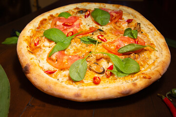 Tasty pizza and cooking ingredients tomatoes basil on black concrete background. Top view of hot pepperoni pizza. 