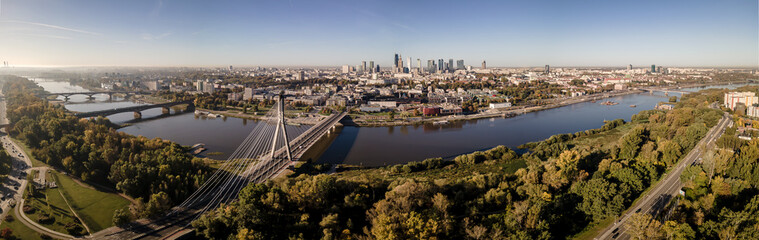 Obraz na płótnie Canvas Aerial view on a sunny ,autumn day on the center of Warsaw ,skyscrapers ,financial centers and the Vistula River and bridges on it.