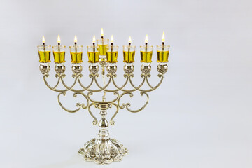In this Hanukkah festival symbols are lit in menorah with Jewish holiday candles on white background with copy space