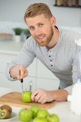 young man cutting apples preparing apple juice