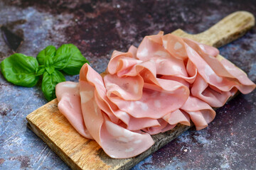 Slices Of  Traditional Italian antipasti mortadella Bolognese  on a wooden  cutting board. © Striker777
