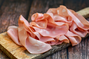 Slices Of  Traditional Italian antipasti mortadella Bolognese  on a wooden  cutting board © Striker777