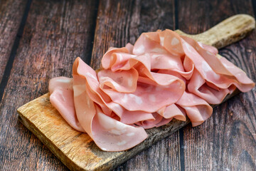 Slices Of  Traditional Italian antipasti mortadella Bolognese  on a wooden  cutting board © Striker777