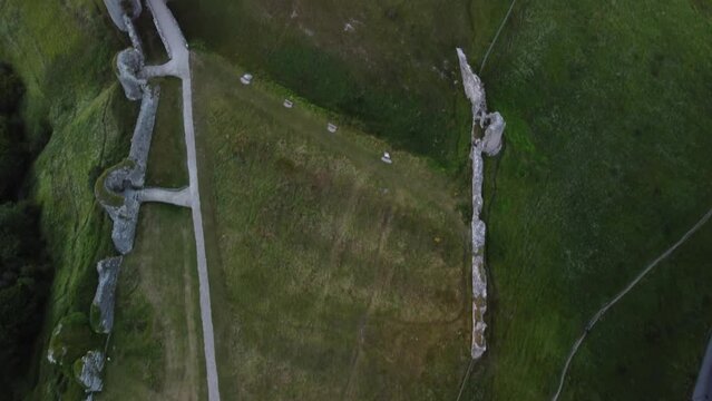 4k drone footage of Corfe Castle on the hill surrounded by green vegetation. England, UK.