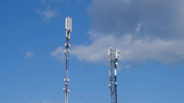 Cell site antenna on a blue sky and white clouds background. Cell tower with mobile Telecommunications equipment. Place for text. Cellular tower base station with electronic communications equipment