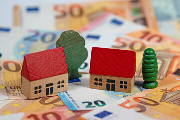 Häuser auf Geldscheinen symbolisch für Grundsteuer