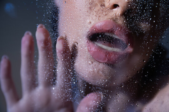 Cropped view of sexy woman touching glass with water drops on grey background.