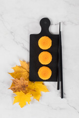 Pumpkin mousse cream dessert with spiral jelly, sprinkled with colored coconut shavings, on a...