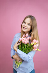 young woman with flowers in her hands on a pink background