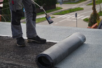 Roofer working on the roof. Roofing felt.