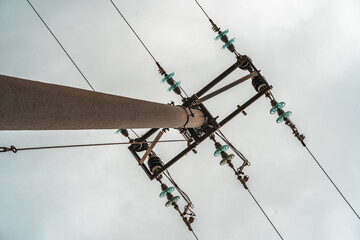 Electric pole and cables seen from below, with clear blue sky in the background