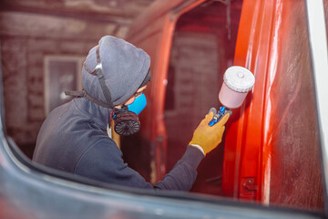 Spray painting a van car red. Restoration and body repair of cars