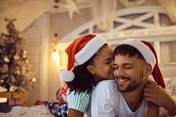 Fototapeta premium Happy man and his African American girlfriend spending Christmas eve together at home.