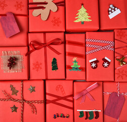 Christmas Presents. Closeup of gifts wrapped in red paper with ribbons and decorations. Square format filling the frame.