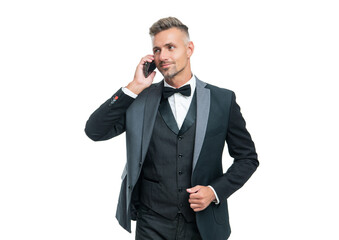 Naklejka premium smiling man in tuxedo speaking on smartphone isolated on white background.