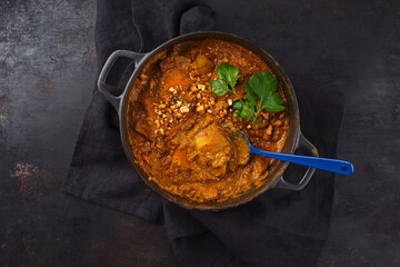 Traditional Indian vegetarian Madras curry stew with sweet potatoes and roasted cashew nuts served...