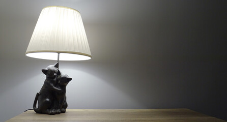 Lampa z figurami kotów na meblu - obrazy, fototapety, plakaty