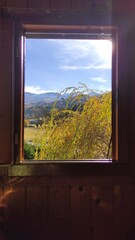 Paysage d'automne au travers d'une fenêtre de chalet