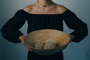 woman holding home decor. bamboo plate with branch balls. High quality photo