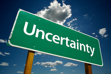Uncertainty Green Road Sign On Cloudy Blue Sky Background