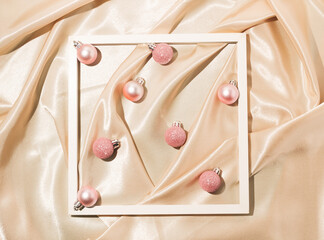 Pink christmas bubbles on gold satin background. Flat lay. Minimal New Year and Christmas concept idea.