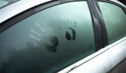 A couple of handprints on the car window. Prints on the fogged glass in the car. Sex in the car....