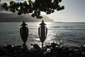 Two Tiki Torches Silhouetted by Sunset Over Hanalei Bay, Kauai