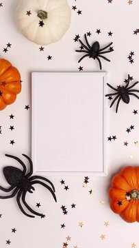 Stop motion animation of mock up flat lay of mini decorative white and orange pumpkin, black spiders and stars from above Halloween and Thanksgiving greeting card holiday concept with copy space.