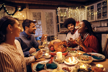 Two happy couples talk during Thanksgiving dinner at dining table.