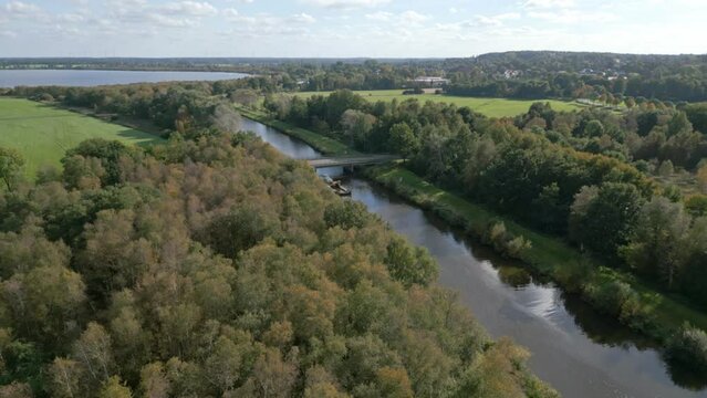 Drone view of a river with a bridge and greenery around