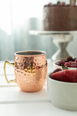 glass with drink and fruits on a plate in the background chocolate cake, drink and food on table