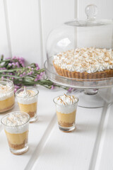 cake in a recent next to glasses with jelly and cream, table decoration, gourmet snacks in studio, delicious pastry