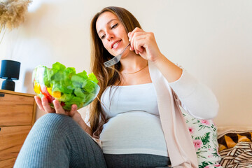 Pregnant woman eating healthy food. Happy pregnancy mother eating nutrition diet salad. Healthy breakfast food concept.