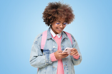 African teenage school girl with afro hairstyle and backpack holding smartphone with both hands