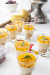 table served with glasses filled with passion fruit cheesecake, delicious desserts in the studio, gourmet pastries