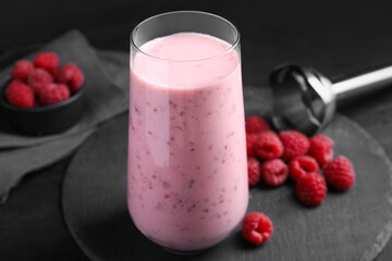 Glass of tasty raspberry smoothie on dark table, closeup