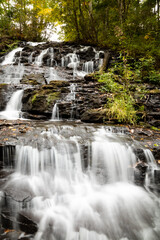 Fototapeta na wymiar cascading waterfall in forest at Vogel State Park Georgia, vertical frame