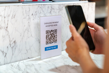 Asian woman enjoy shopping at street market on summer holiday vacation. Attractive girl using mobile phone scan QR code on bar counter making online payment buying iced coffee at outdoor coffee shop.