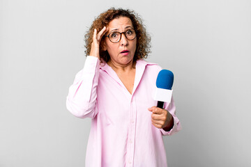 pretty middle age woman looking surprised, realizing a new thought, idea or concept. tv presenter...
