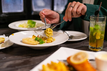 Asian couple celebrating holiday event at luxury restaurant bar in the city at night. Attractive man and woman enjoy city lifestyle shopping and having dinner with food and drink on travel vacation