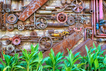 Fototapeta na wymiar old rusty gear wheels with green plant