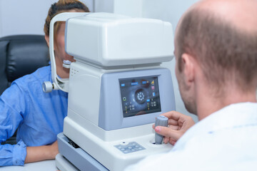 Handsome male ophthalmologist is examining the vision of an attractive young woman in a modern clinic, doctors and patients in ophthalmology clinics.