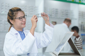Female ophthalmologist holding eyeglasses and examining them, focus on eyeglasses, close-up