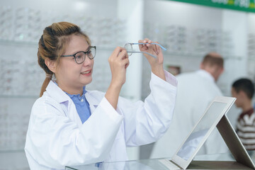 Female ophthalmologist holding eyeglasses and examining them, focus on eyeglasses, close-up